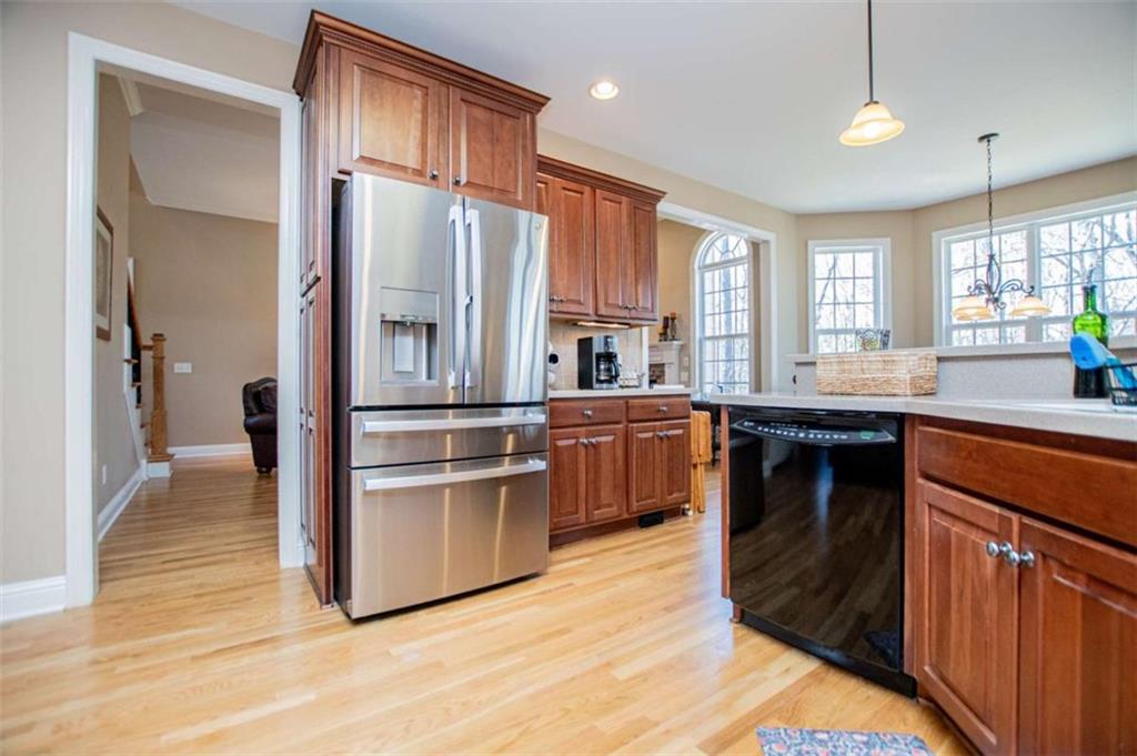 6170 Hedgestone Way Douglasville, GA 30135 - Photo 20 of 106 a kitchen with stainless steel appliances granite countertop a refrigerator a sink dishwasher a stove and white countertops with wooden floor