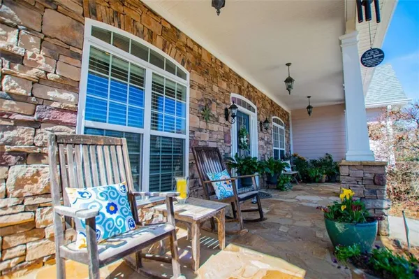 a view of a patio with couches table and chairs and potted plants