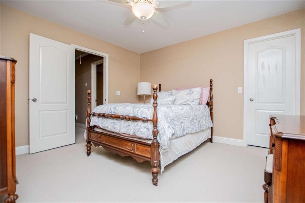 6170 Hedgestone Way Douglasville, GA 30135 - Photo 44 of 106 a bedroom with a bed and a chandelier