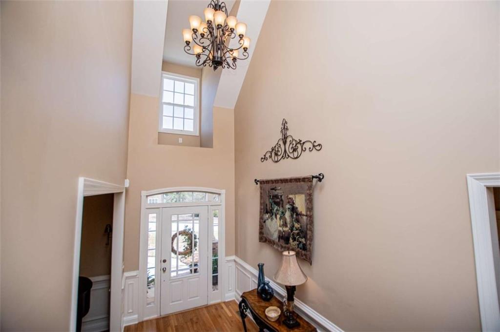6170 Hedgestone Way Douglasville, GA 30135 - Photo 5 of 106 a view of a hallway with wooden floor and a chandelier