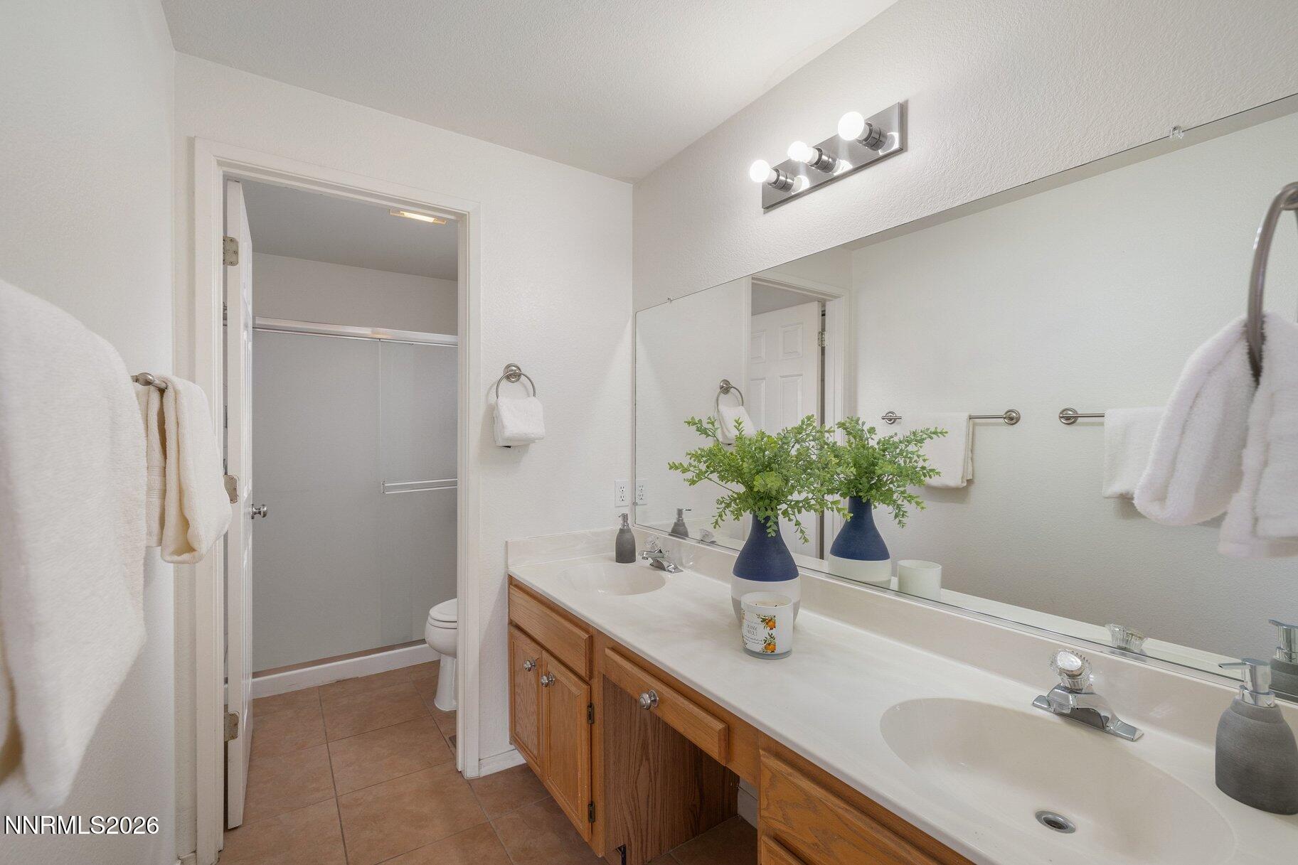 8486 Piper Place Reno, NV 89506 - Photo 18 of 80 a bathroom with a double vanity sink mirror and shower