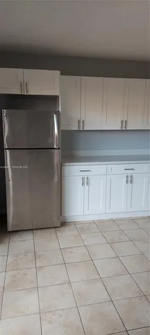 a view of a kitchen with white cabinets