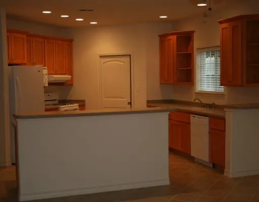 a kitchen with kitchen island granite countertop cabinets and refrigerator