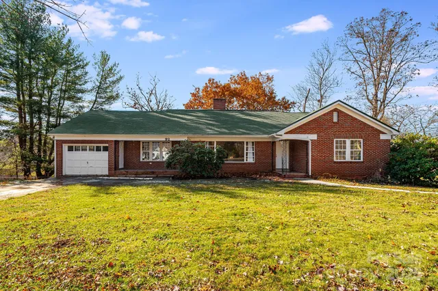 a view of a swimming pool with a patio and a yard