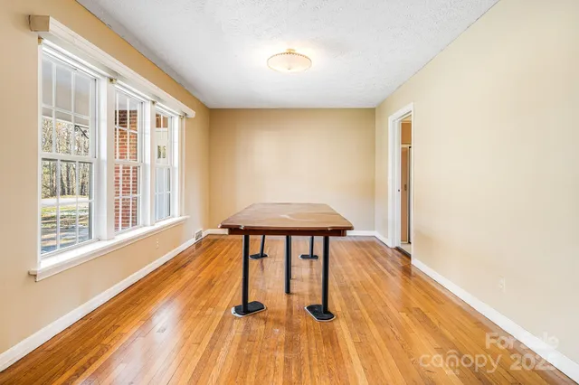 a view of a room with wooden floor and a window
