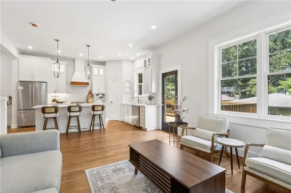a living room with lots of furniture and a view of kitchen
