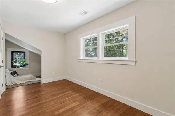 an empty room with wooden floor and windows