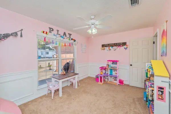 a living room with baby crib furniture and a book shelf