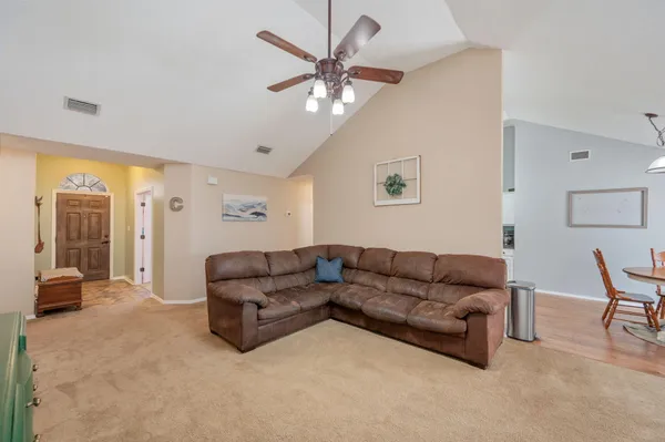 a living room with furniture a clock and a flat screen tv