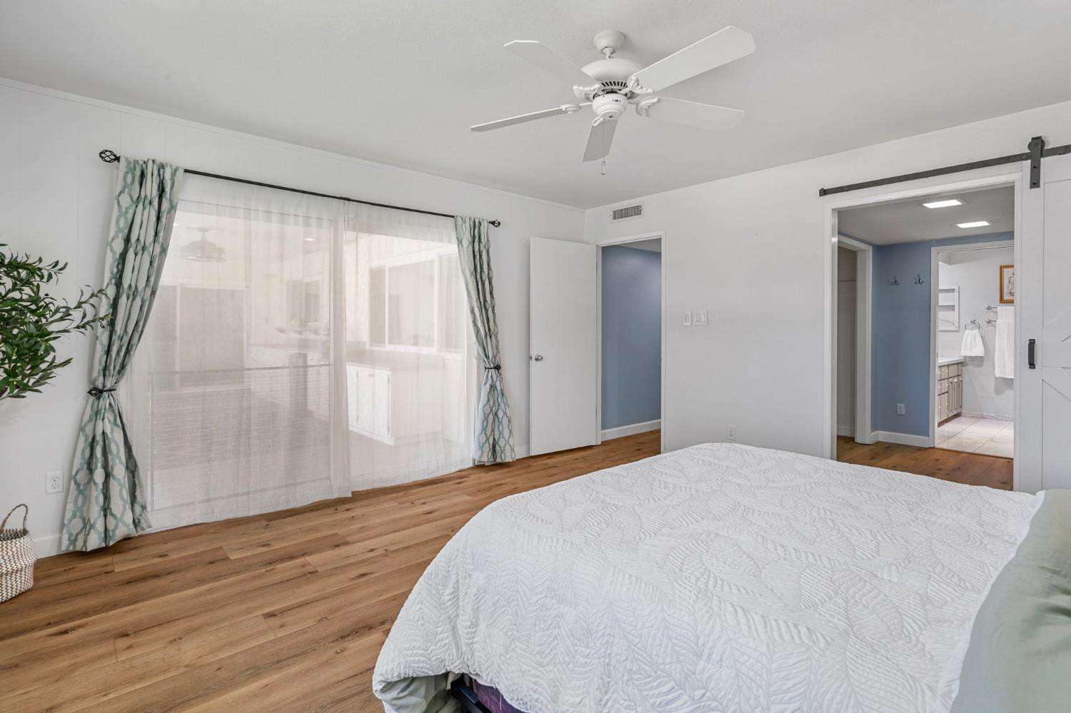 2433 Broadridge Way Stockton, CA 95209 - Photo 20 of 67 a bedroom with a large bed and a chandelier