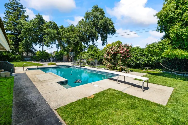a swimming pool with outdoor seating and yard