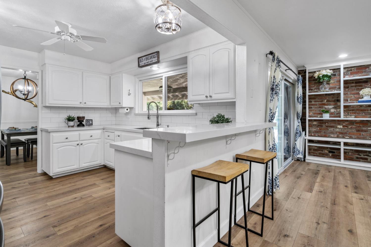 2433 Broadridge Way Stockton, CA 95209 - Photo 31 of 67 a kitchen with stainless steel appliances a stove a sink dishwasher a refrigerator with white cabinets and wooden floor