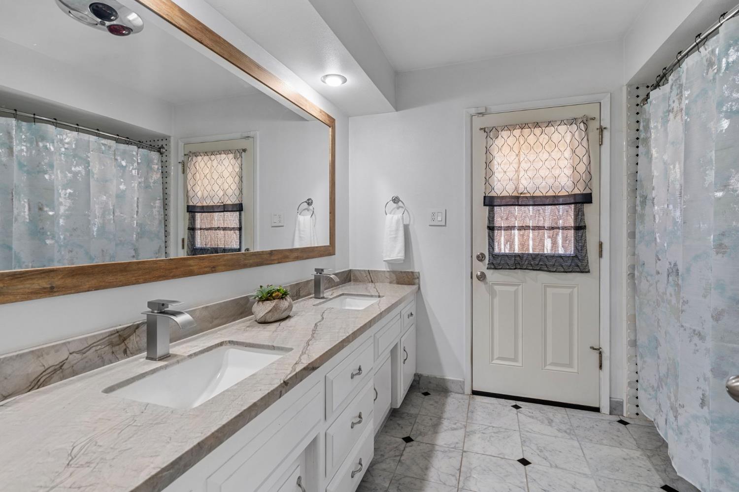 2433 Broadridge Way Stockton, CA 95209 - Photo 39 of 67 a spacious bathroom with double vanity and a mirror