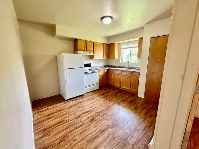 a kitchen with a sink wooden floor and stainless steel appliances