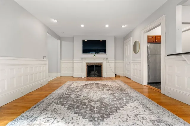 a view of empty room with a fireplace and a flat screen tv