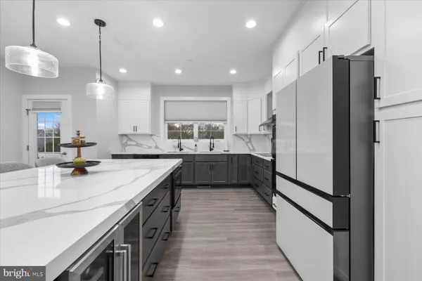 a kitchen with stainless steel appliances granite countertop a sink refrigerator and cabinets