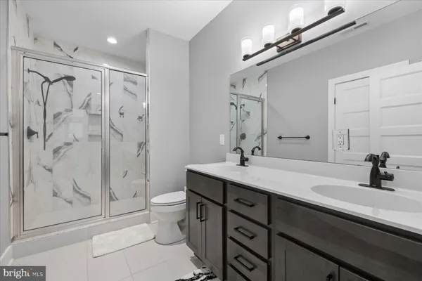 a bathroom with a double vanity sink toilet and shower