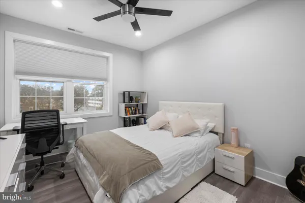 a bedroom with a bed wooden floor and a window