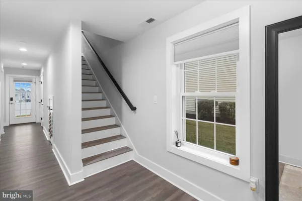 a view of a hallway with wooden floor and windows