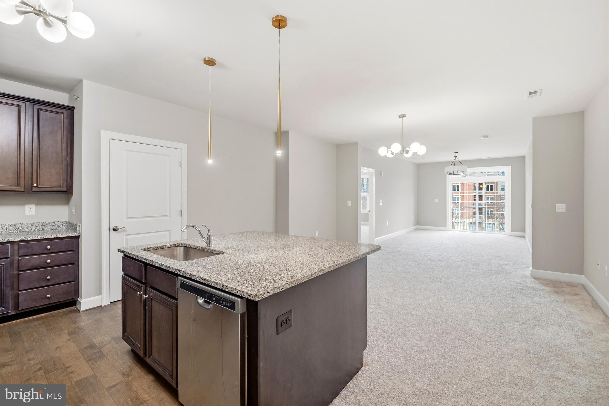 10520 Resort Road, Unit 303 Ellicott City, MD 21042 - Photo 3 of 11 a kitchen with kitchen island granite countertop a sink a counter top space and living room view