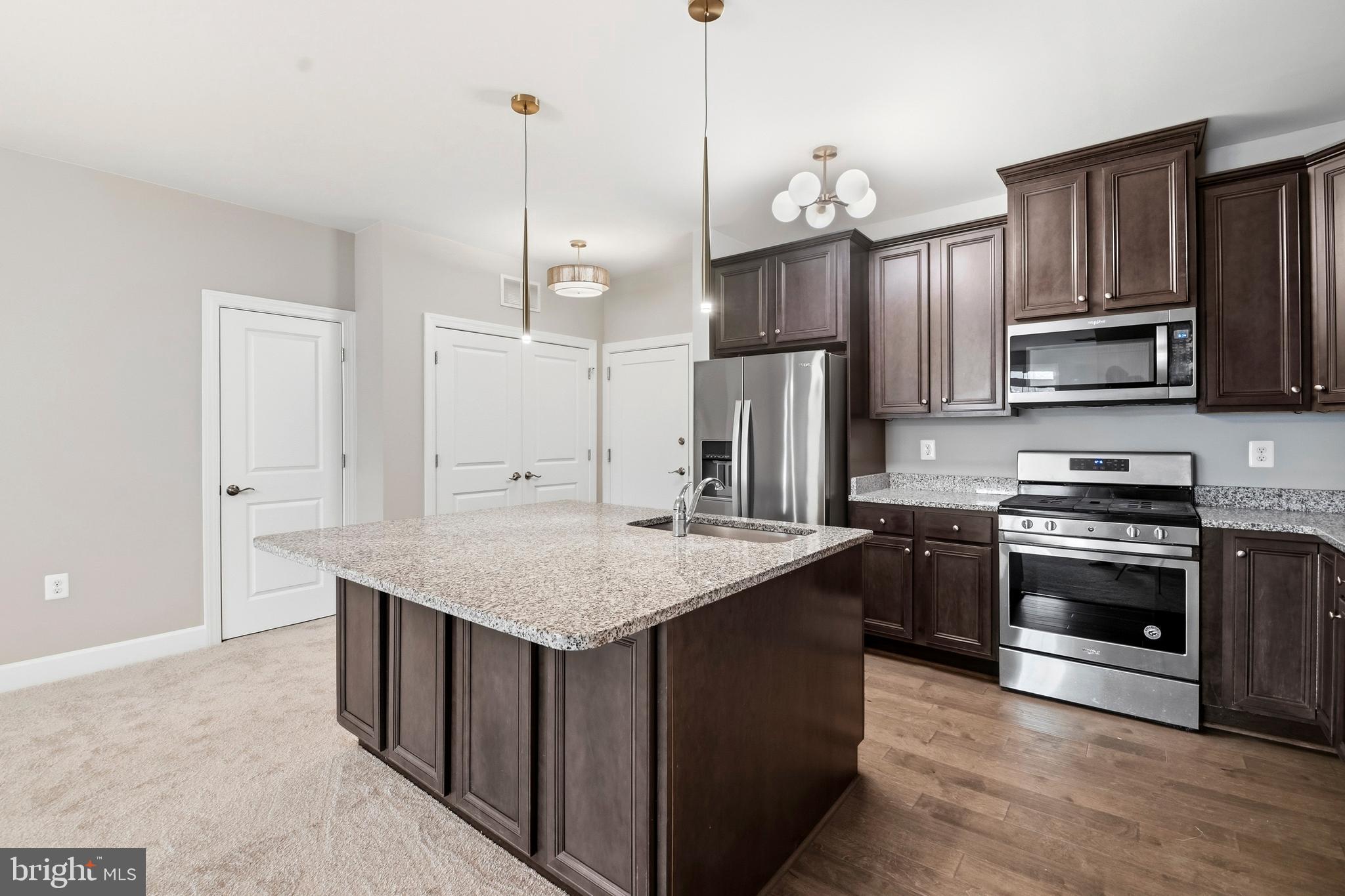 10520 Resort Road, Unit 303 Ellicott City, MD 21042 - Photo 4 of 11 a kitchen with stainless steel appliances granite countertop a sink stove and refrigerator