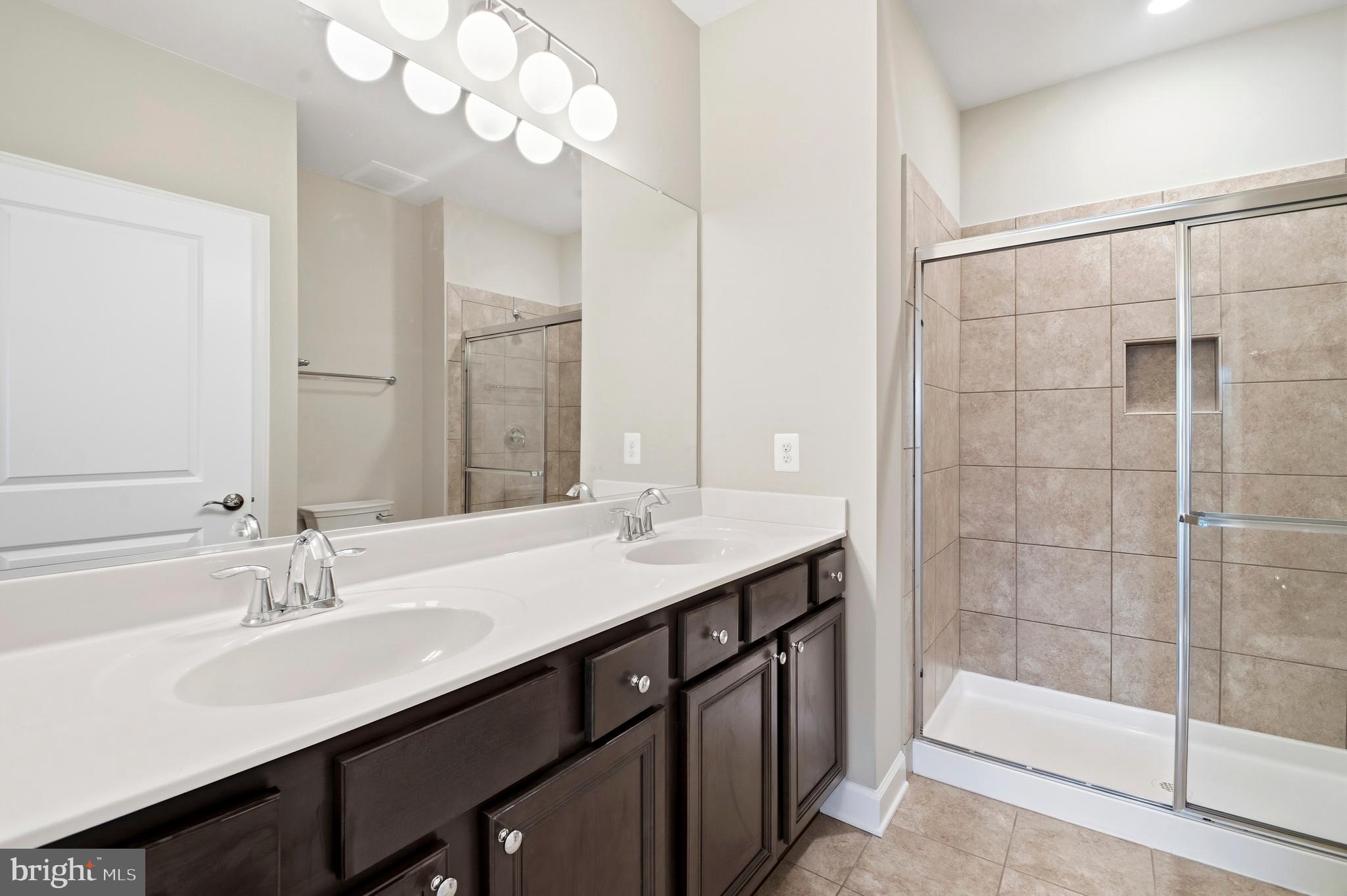 10520 Resort Road, Unit 303 Ellicott City, MD 21042 - Photo 9 of 11 a bathroom with a sink double vanity and a shower