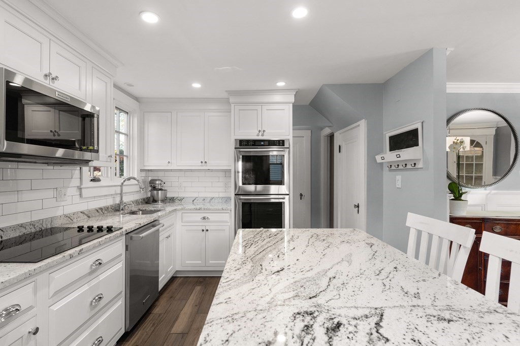 63 Oak Ridge Road Medford, MA 02155 - Photo 22 of 40 a kitchen with stainless steel appliances kitchen island granite countertop a stove top oven a sink dishwasher a refrigerator and a microwave