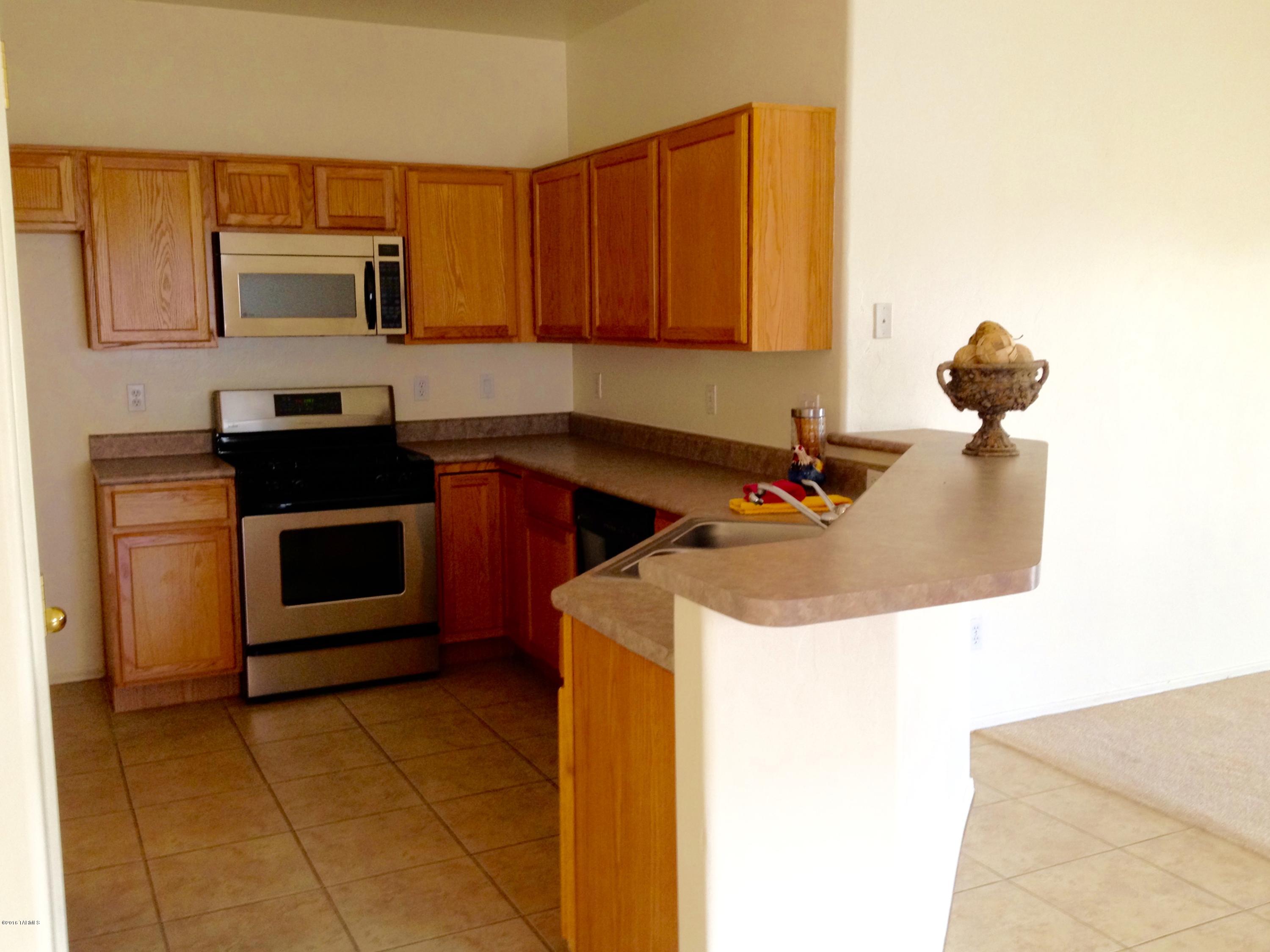 7931 North Iron Ridge Drive Tucson, AZ 85743 - Photo 9 of 21 a kitchen with a sink and a stove top oven
