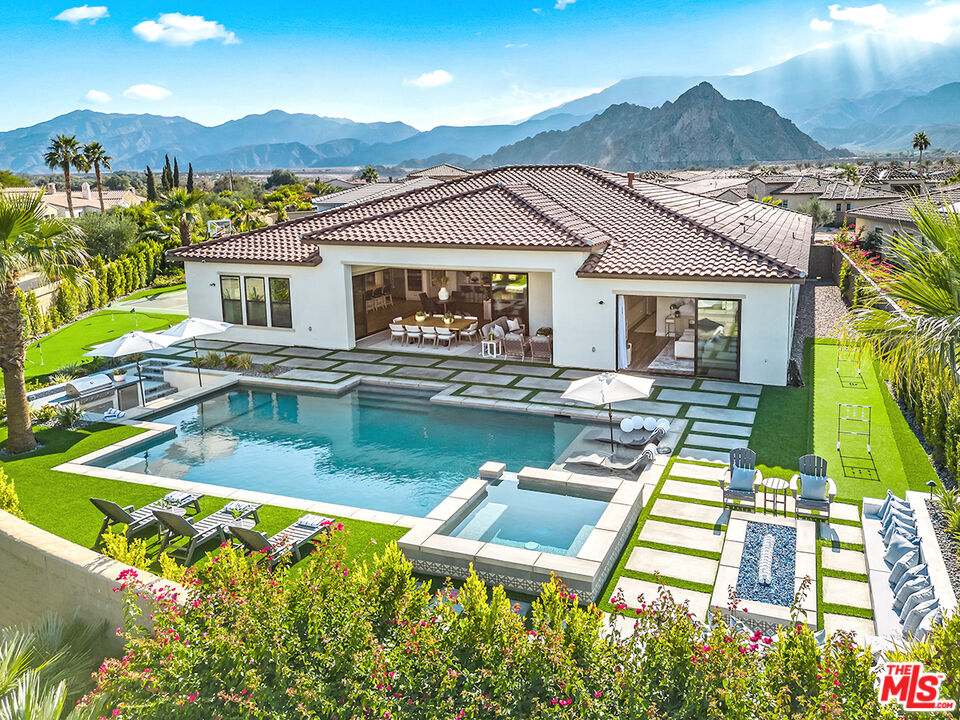 80464 Old Rnch Trail North La Quinta, CA 92253 - Photo 1 of 42 a view of a house with pool lawn chairs and a dining table with chairs