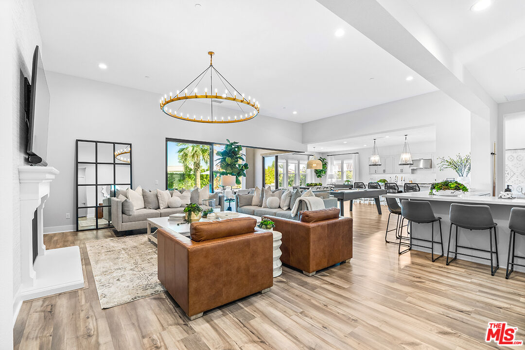 80464 Old Rnch Trail North La Quinta, CA 92253 - Photo 12 of 42 a living room with furniture a dining table and a floor to ceiling window