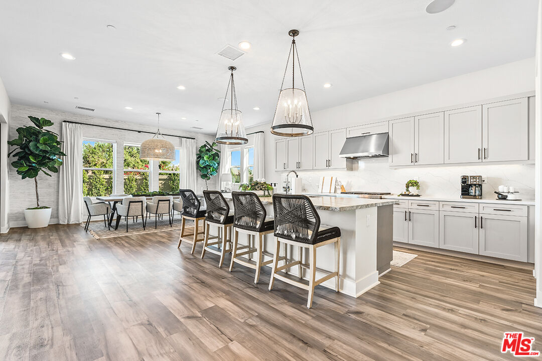 80464 Old Rnch Trail North La Quinta, CA 92253 - Photo 15 of 42 a kitchen with stainless steel appliances kitchen island wooden floors and white cabinets