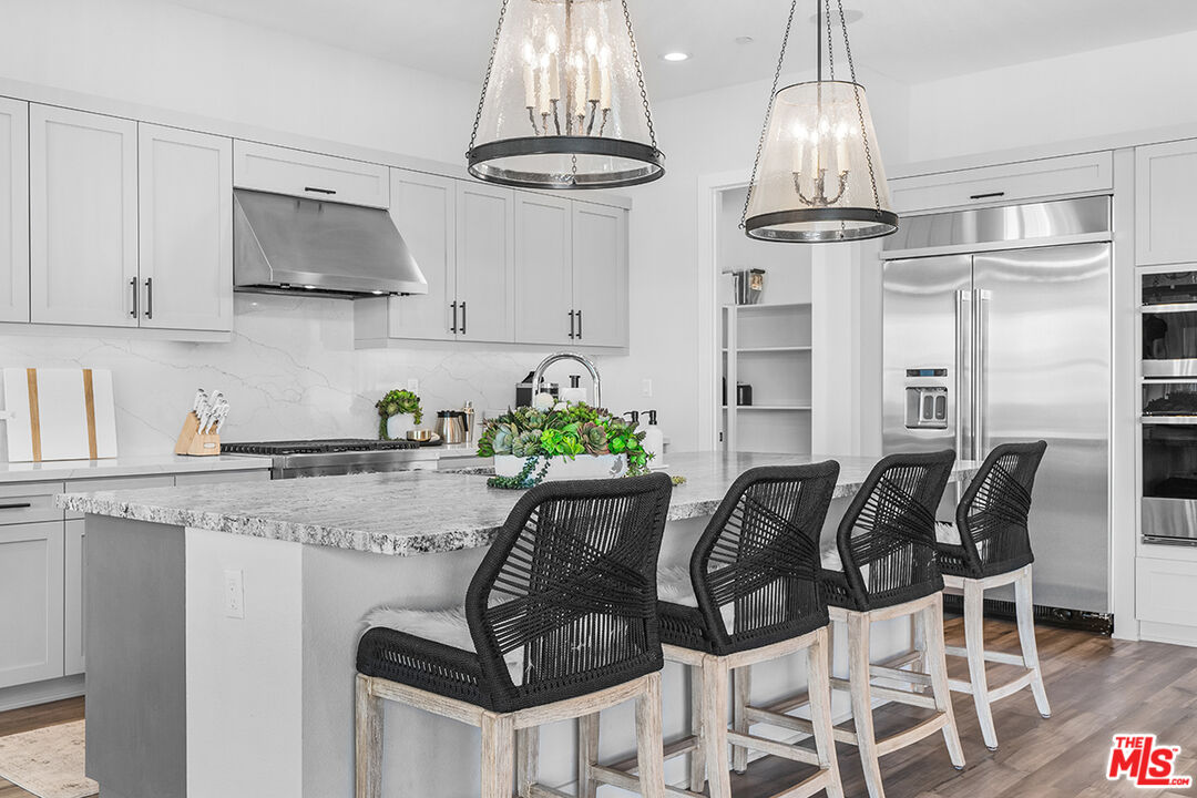 80464 Old Rnch Trail North La Quinta, CA 92253 - Photo 17 of 42 a kitchen with stainless steel appliances granite countertop a table and chairs in it