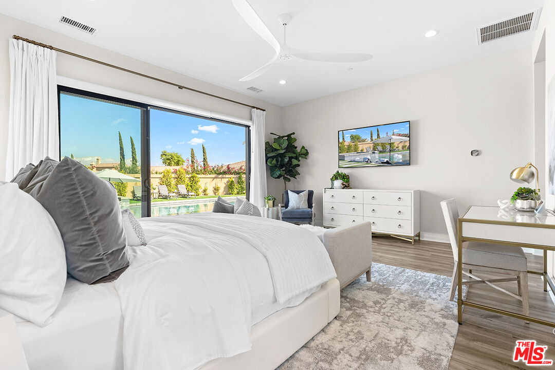 80464 Old Rnch Trail North La Quinta, CA 92253 - Photo 20 of 42 a spacious bedroom with a bed a table and painting on the wall