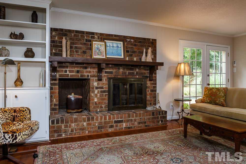 2942 Buckingham Road Durham, NC 27707 - Photo 11 of 25 a living room with furniture a flat screen tv and a fireplace