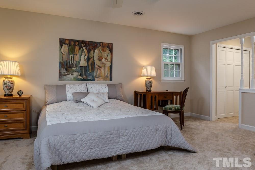2942 Buckingham Road Durham, NC 27707 - Photo 14 of 25 a bedroom with a bed a mirror and a window