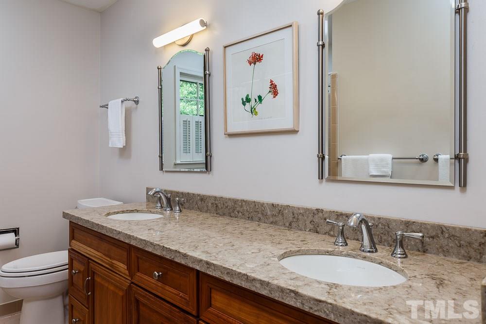 2942 Buckingham Road Durham, NC 27707 - Photo 17 of 25 a bathroom with a granite countertop sink and a mirror