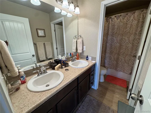 a bathroom with a sink double vanity granite tub shower and a mirror