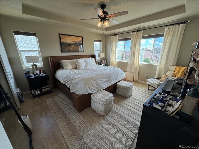 a spacious bedroom with a bed a couch and a chandelier