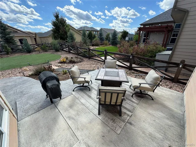 a view of a patio with couches table and chairs with wooden fence