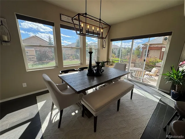 a dining room with furniture a chandelier and wooden floor