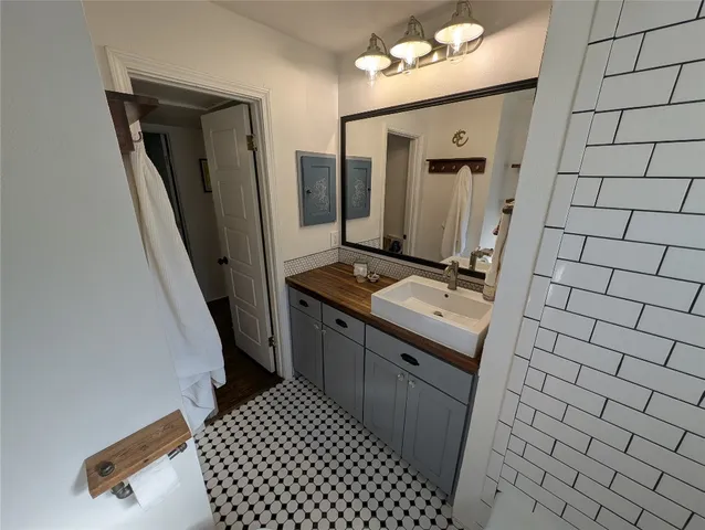 a bathroom with a sink and mirror with toilet