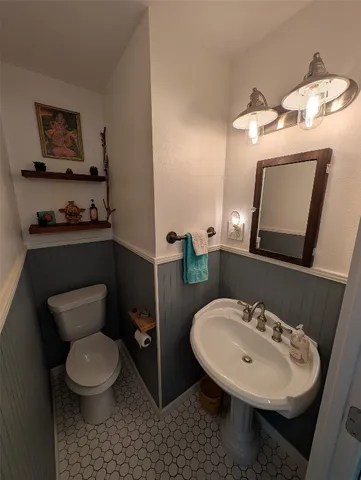 a bathroom with a toilet a sink and mirror