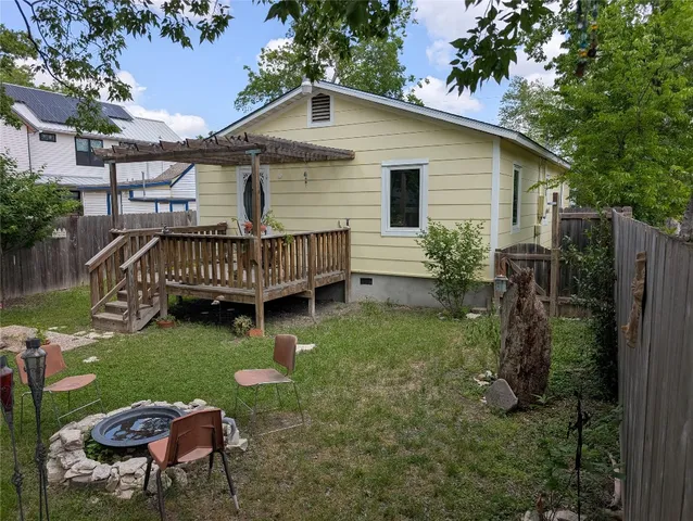a view of a chair and table in backyard of the house