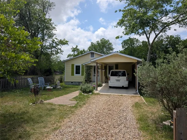 a view of a house with a yard and potted plants