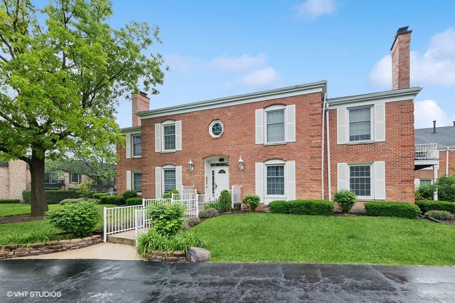 128 Carriage Way Drive, Unit 217B Burr Ridge, IL 60527 - Photo 1 of 20 a front view of a house with garden