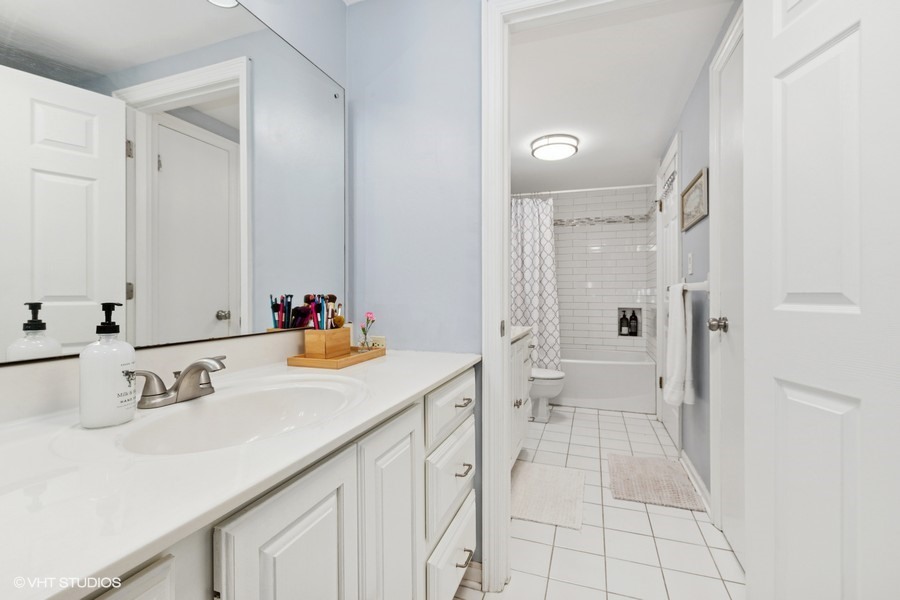 128 Carriage Way Drive, Unit 217B Burr Ridge, IL 60527 - Photo 12 of 20 a bathroom with a sink vanity granite and a mirror