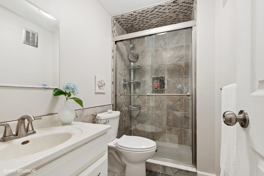 128 Carriage Way Drive, Unit 217B Burr Ridge, IL 60527 - Photo 17 of 20 a bathroom with a sink toilet and shower