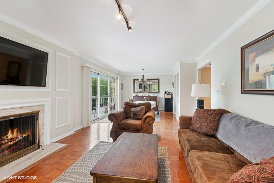 128 Carriage Way Drive, Unit 217B Burr Ridge, IL 60527 - Photo 5 of 20 a living room with furniture and a fireplace