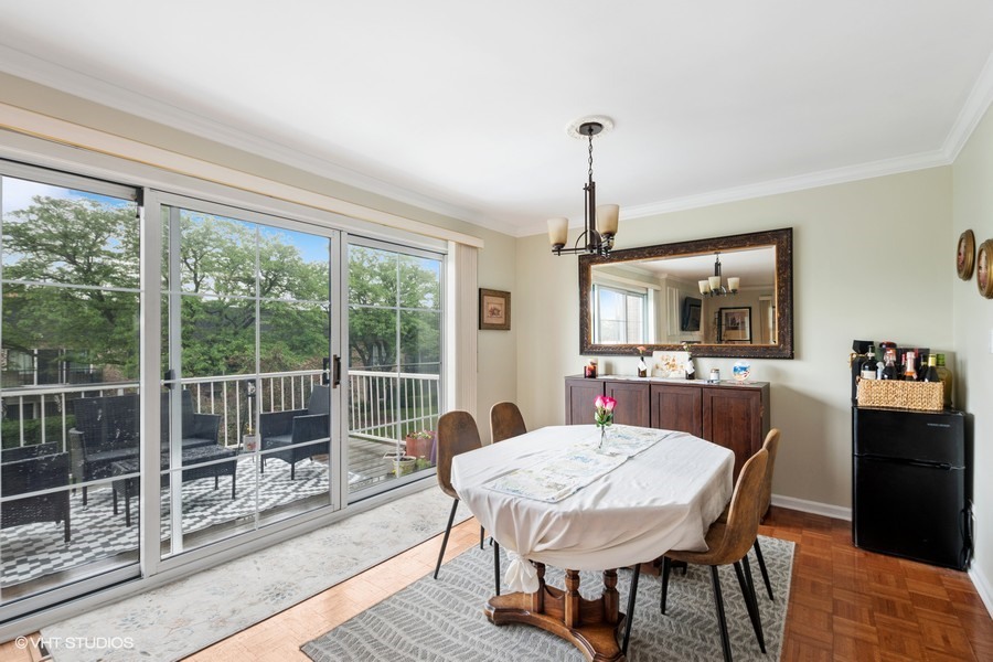 128 Carriage Way Drive, Unit 217B Burr Ridge, IL 60527 - Photo 9 of 20 a dining room with furniture a chandelier and wooden floor