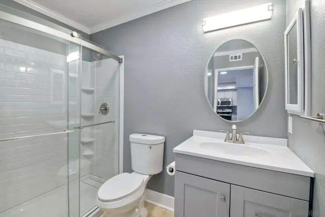 a bathroom with a sink a toilet and shower